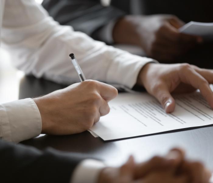 Person sitting as a desk writing on a paper image